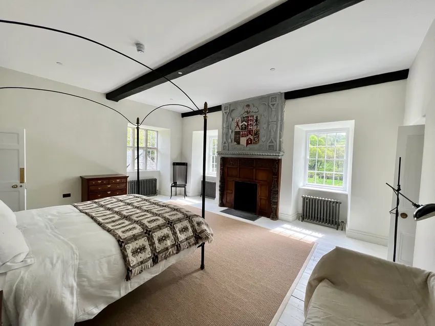 historic bedroom at glyn cywarch estate with wall plaque and traditional fireplace